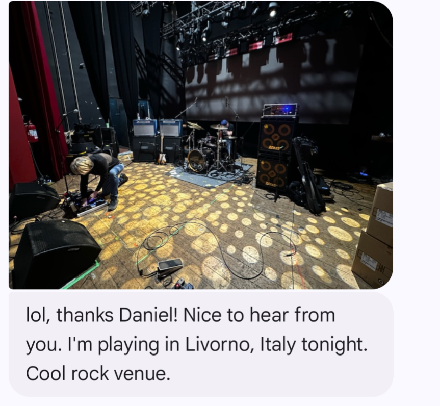 A screenshot of a text message thread with a picture of a music venue stage with lights, drums, pedal boards...and the text "Nice to hear from you. I'm playing in Livorno, Italy tonight..."