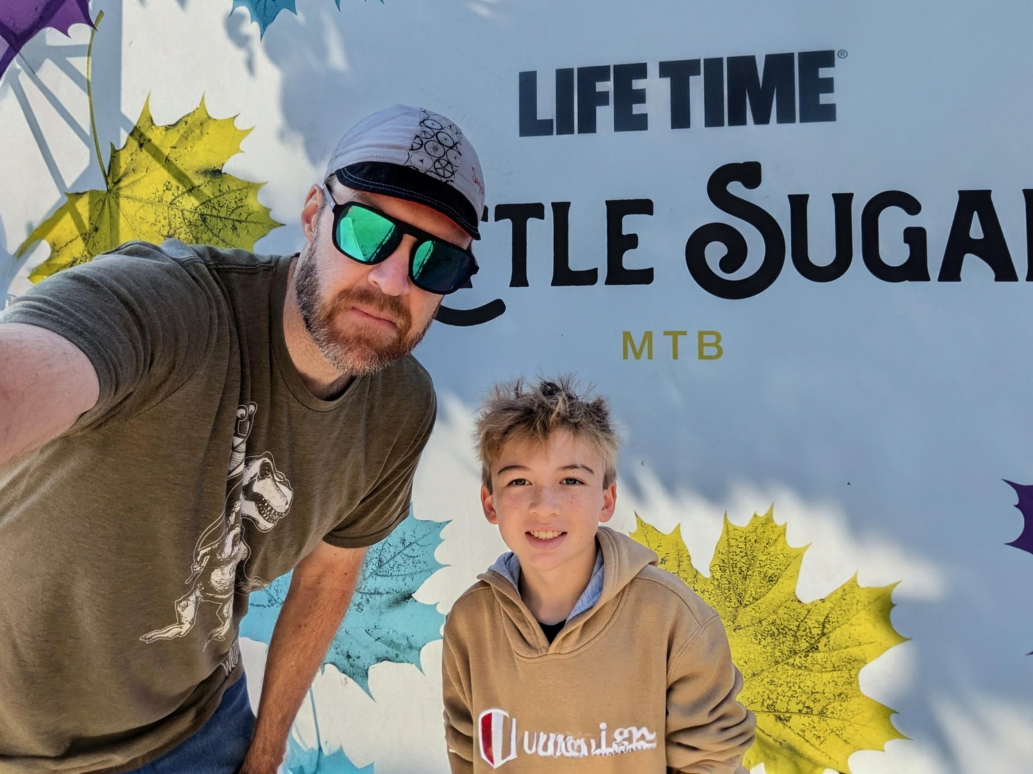 Myself and my son in front of the Little Sugar bike race banner 