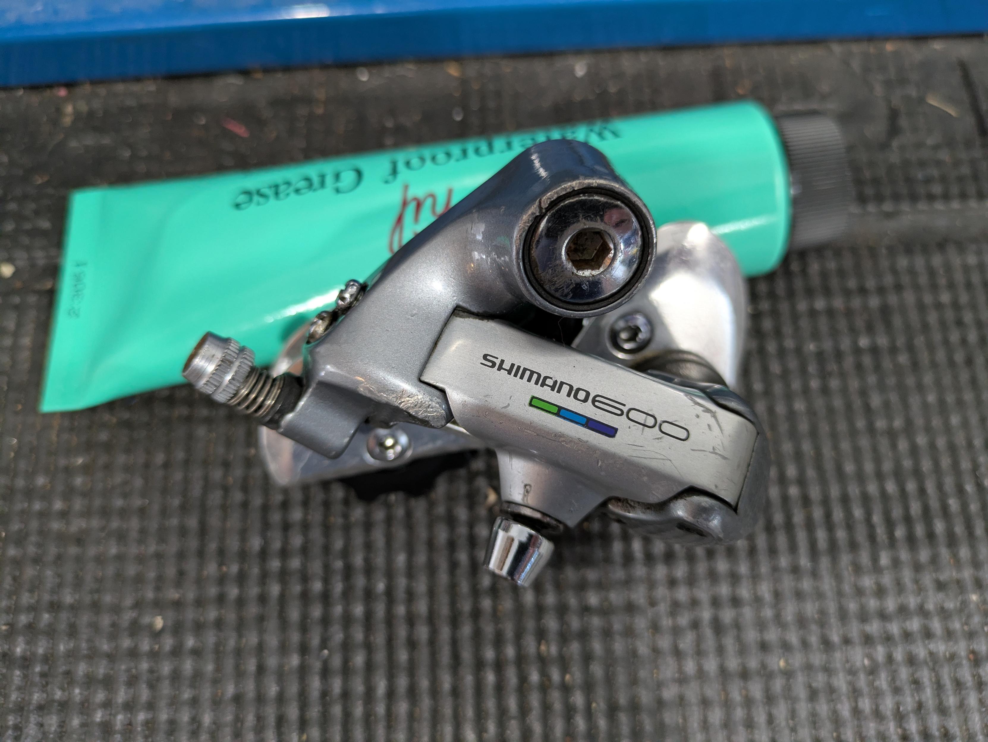 close-up shot of a vintage Shimano 600 rear derailleur sitting on a workbench