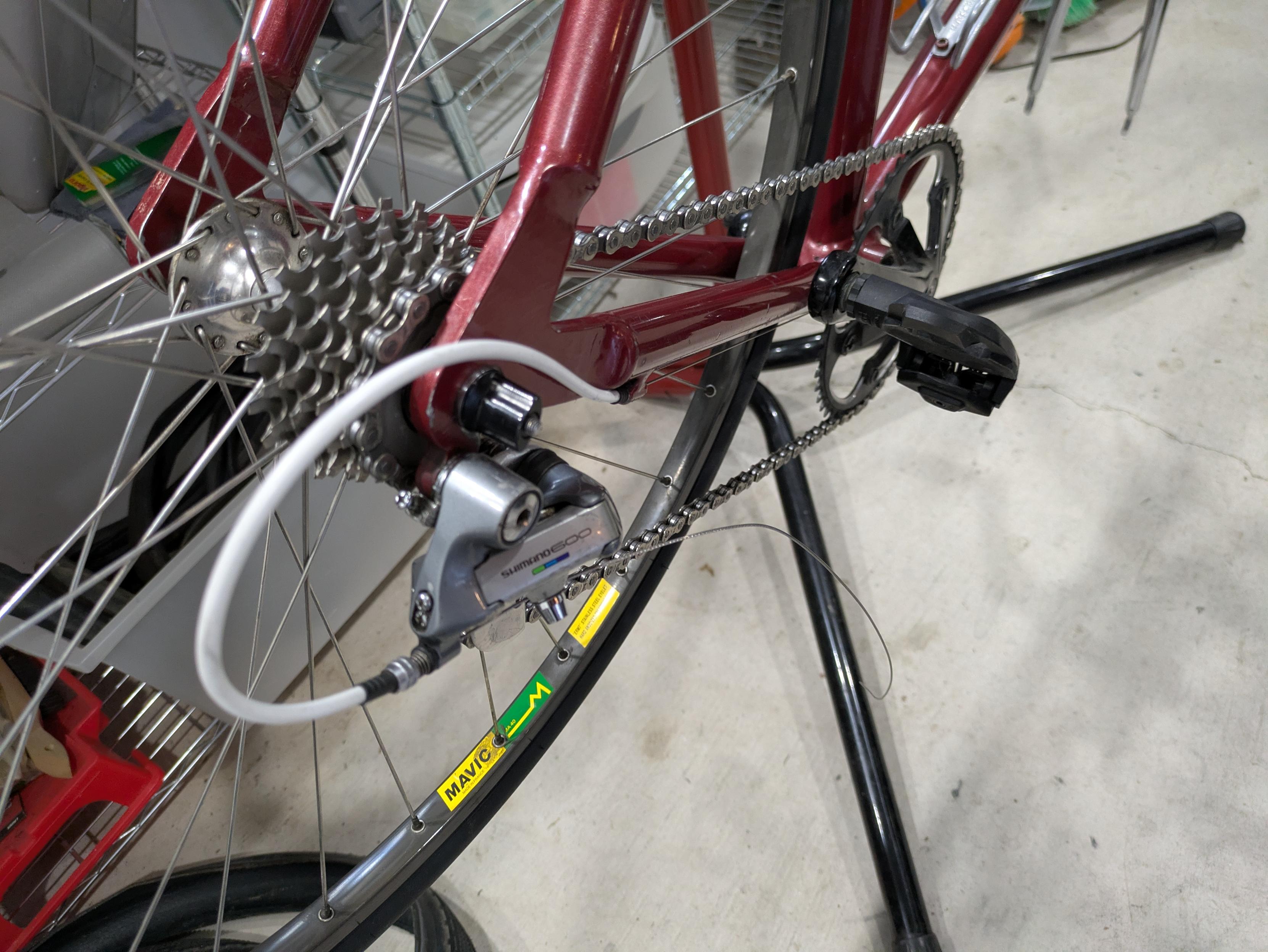 The Shimano 600 derailleur is now mounted on a red road bike, with the bike positioned on a repair stand